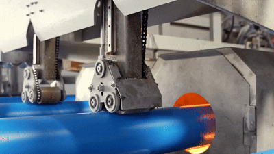 UPVC pipe extrusion process at Al Hilal Plastic factory, Al Hilal Industrial Group – blue UPVC pipe moving through the haul-off unit on the production line